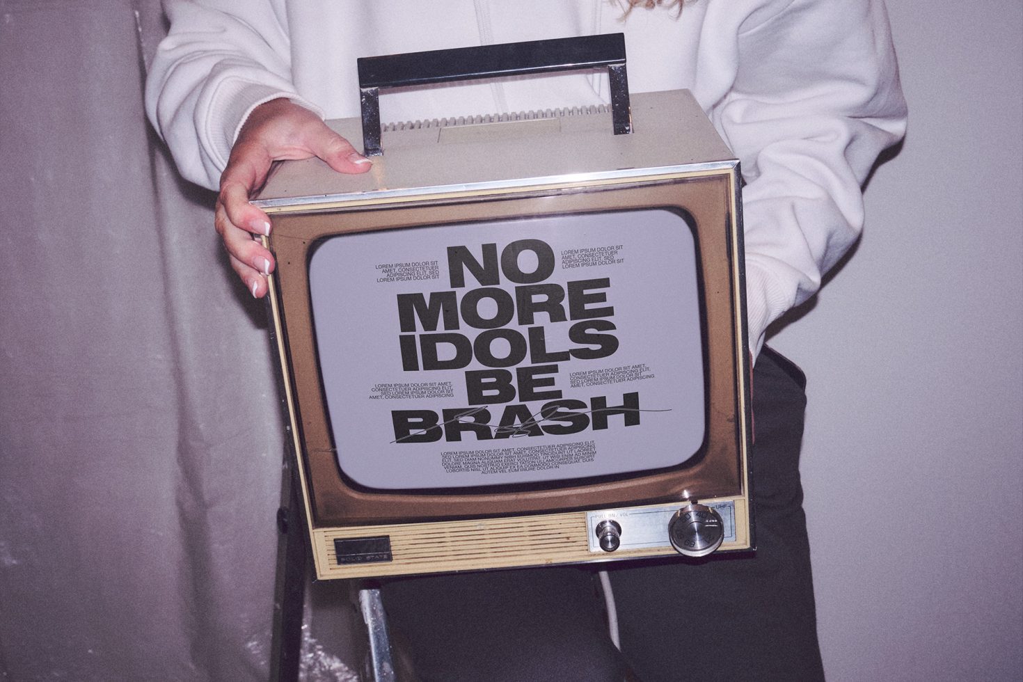 Person holding a vintage TV with bold typography design mockup, ideal for retro graphics presentations and designs.